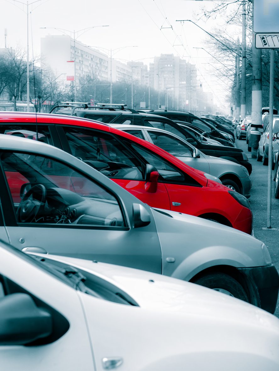 Many cars parked on the sidewalk and street in Bucharest, Romania.