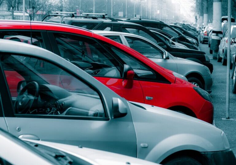 Many cars parked on the sidewalk and street in Bucharest, Romania.